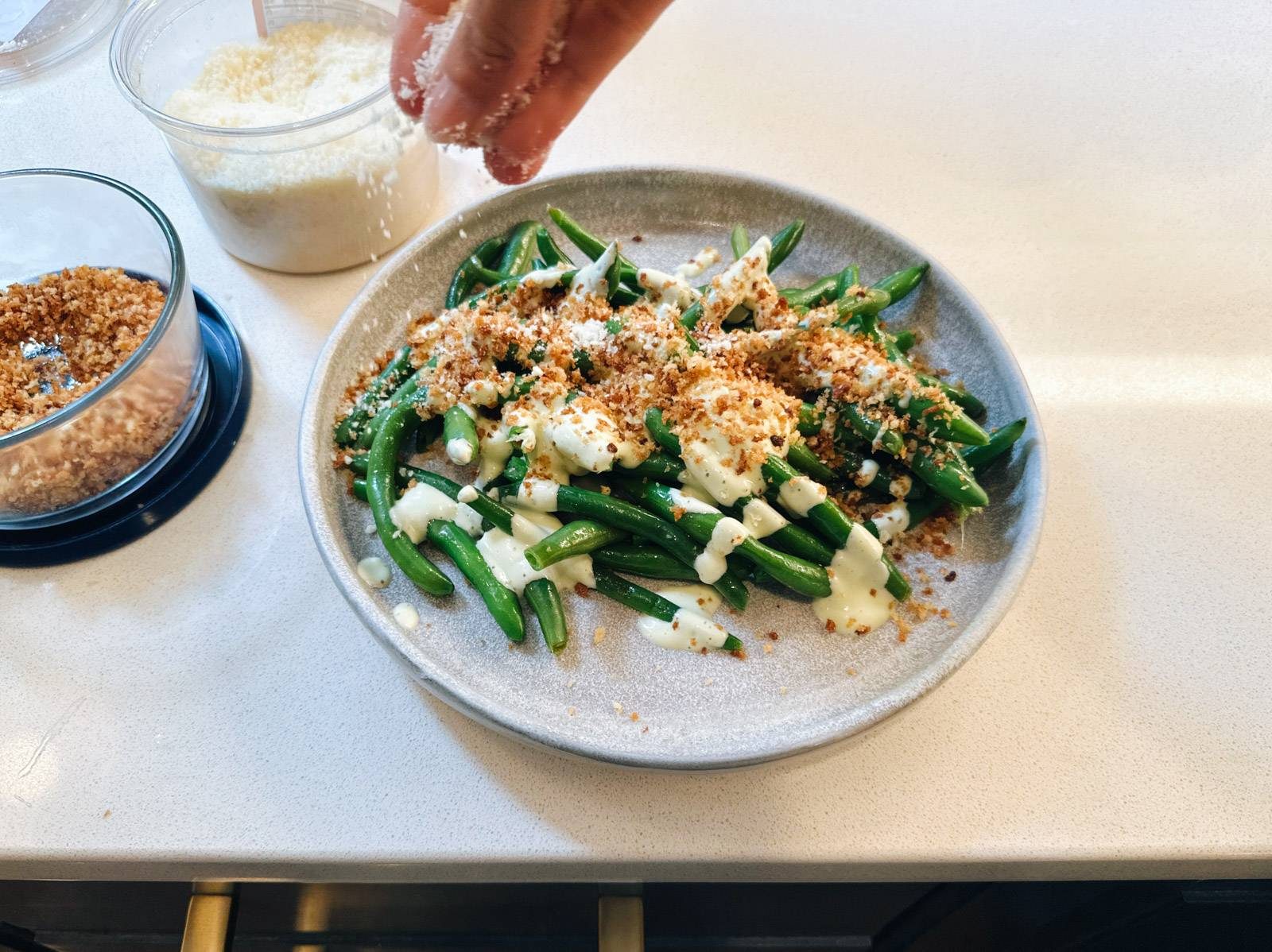 Sprinkling panko on green beans.