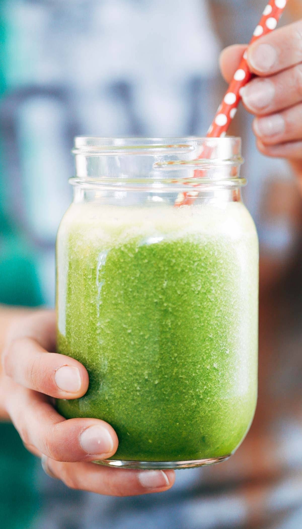 Coconut Green Smoothie in a jar with a red straw.