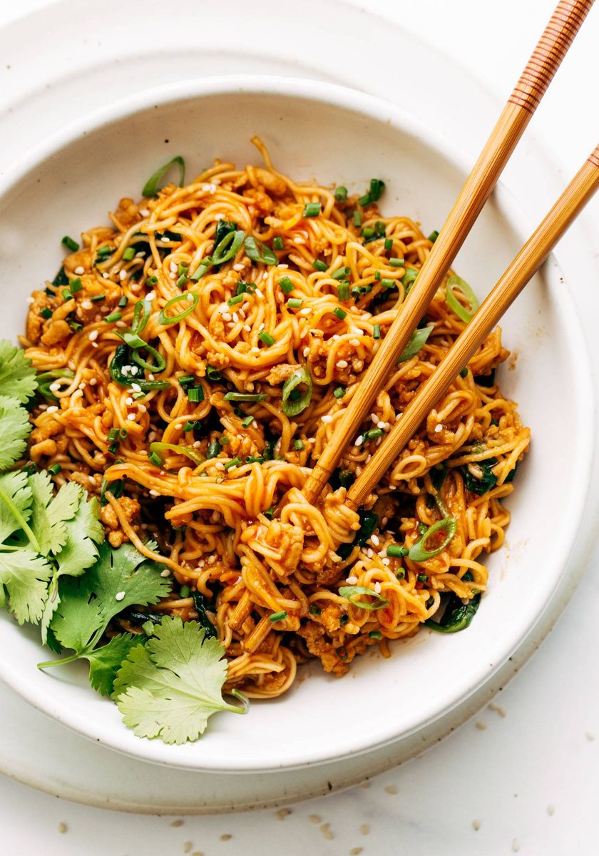 Bowl of gochujang noodles with chopsticks.