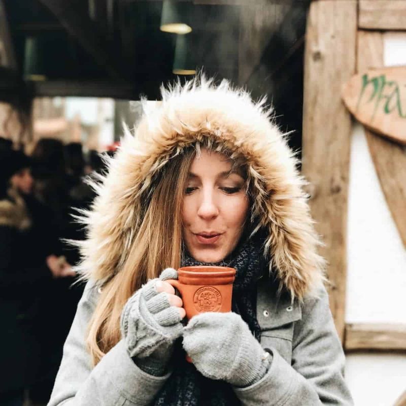 Lindsay holding a mug of mulled wine.