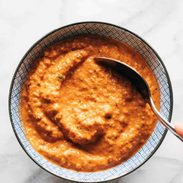 Romesco sauce in a bowl with a spoon.